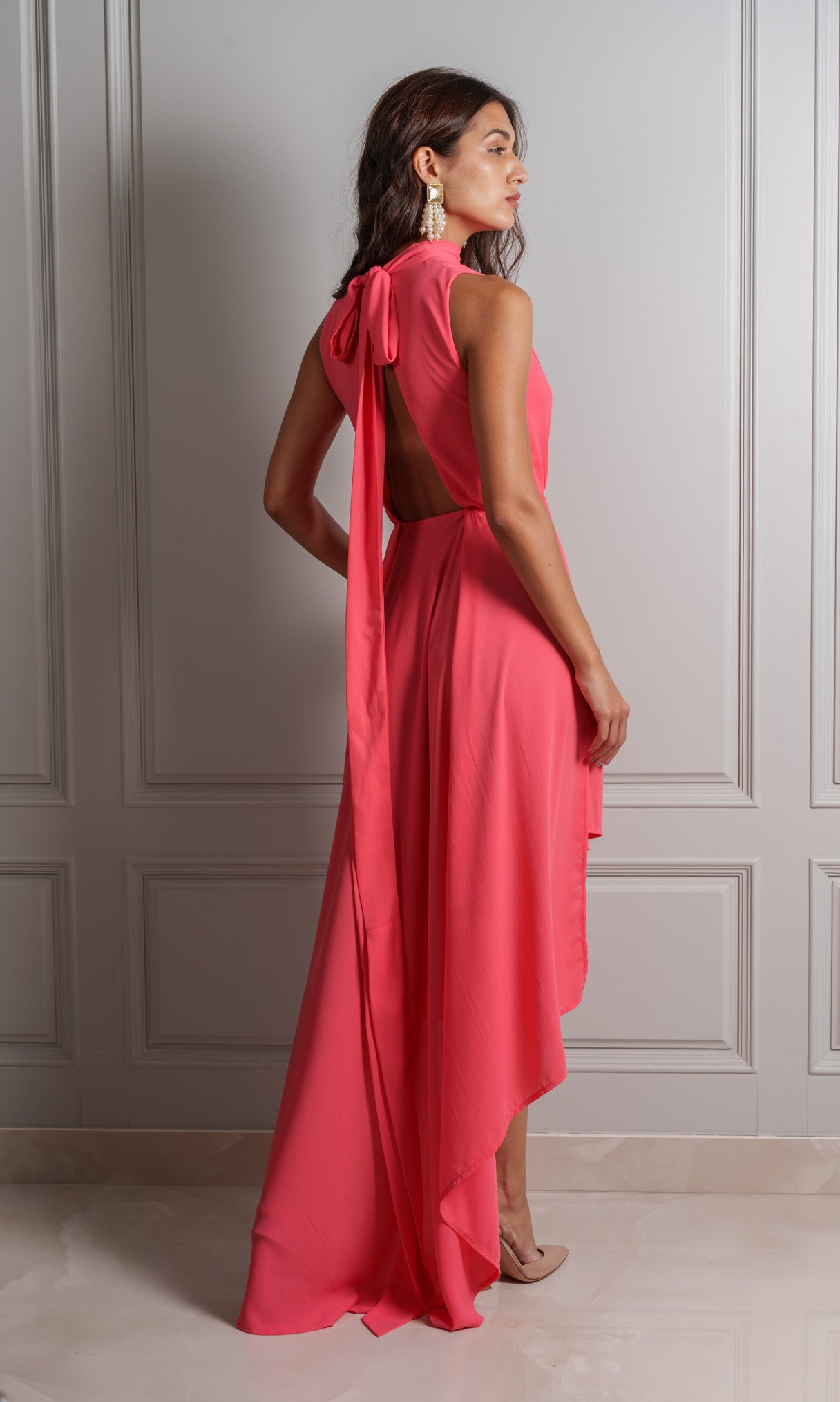 Model wears chiffon fabric dress, lightweight and airy texture drapes softly against the skin in a coral peach colour