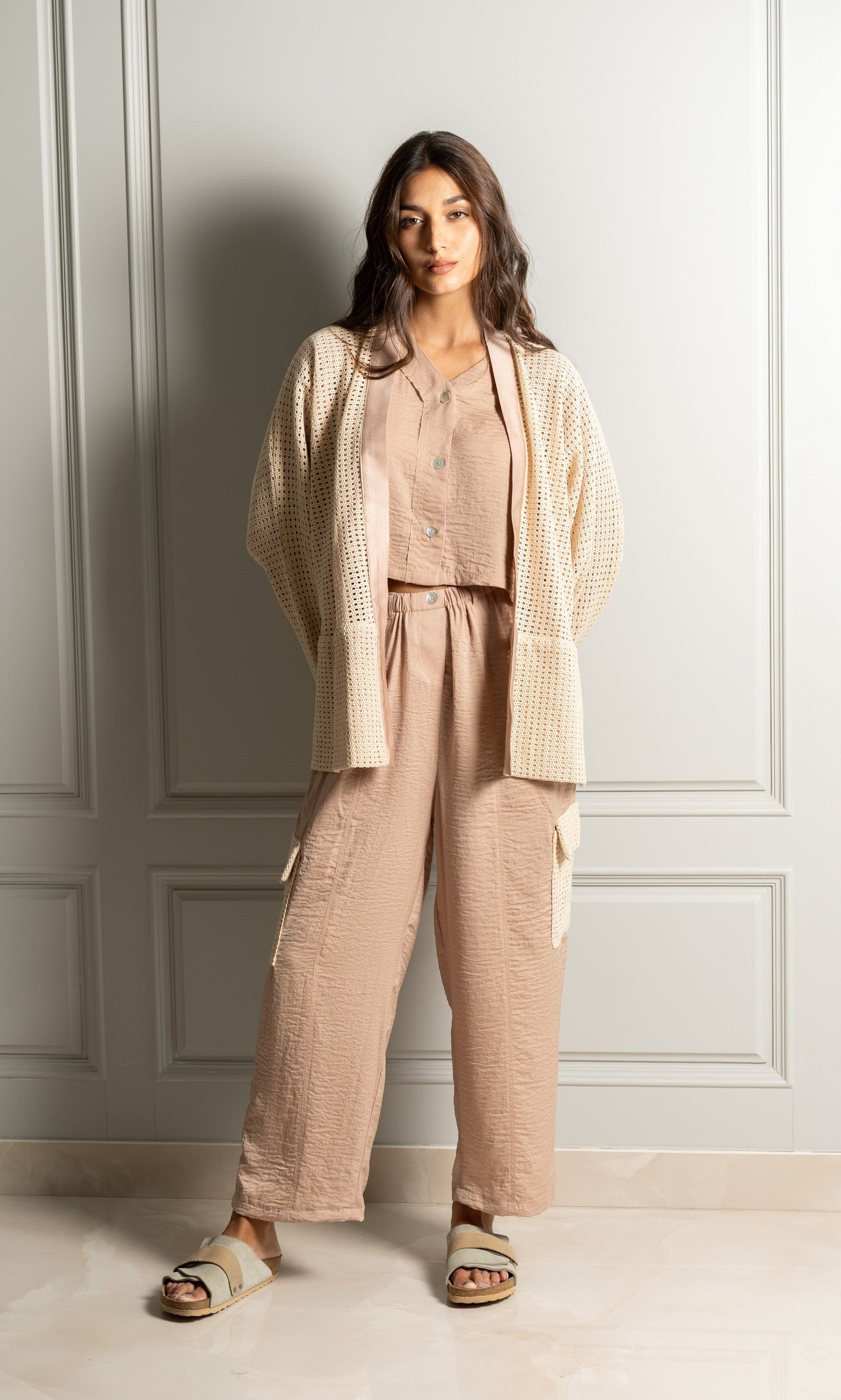 Model wears three-piece set includes a luxurious satin blend button-up shirt, paired with relaxed-fit trousers that feature an elasticated waistband