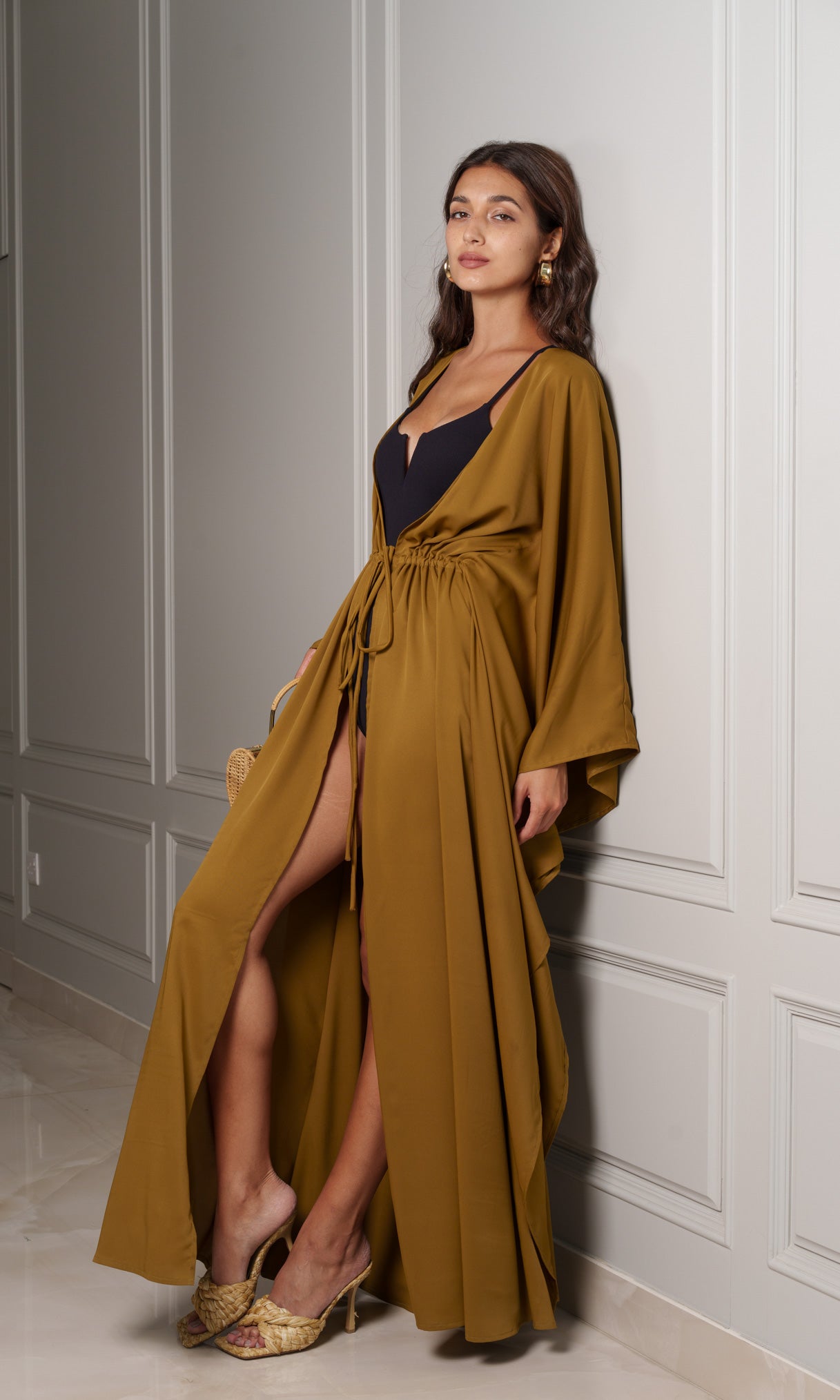 Model wears draped kaftan in a shade of mustard